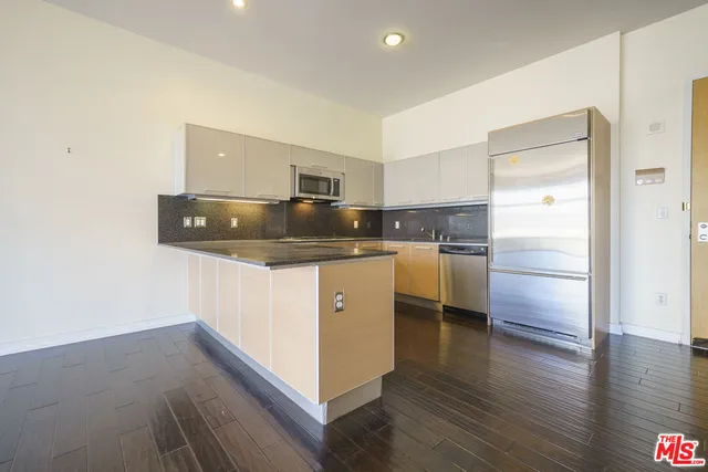 a kitchen with a refrigerator sink and cabinets