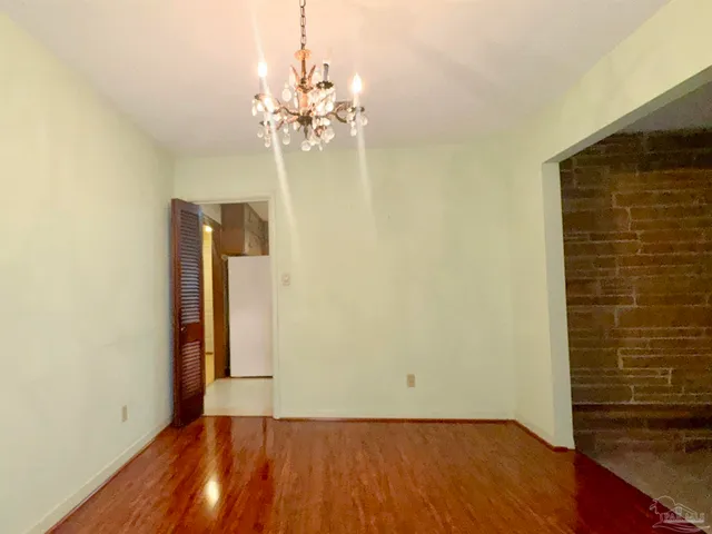 a view of a room with wooden floor and chandelier