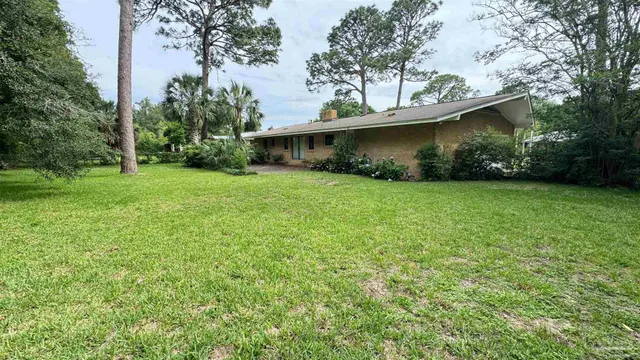 a view of a house with a yard and a tree