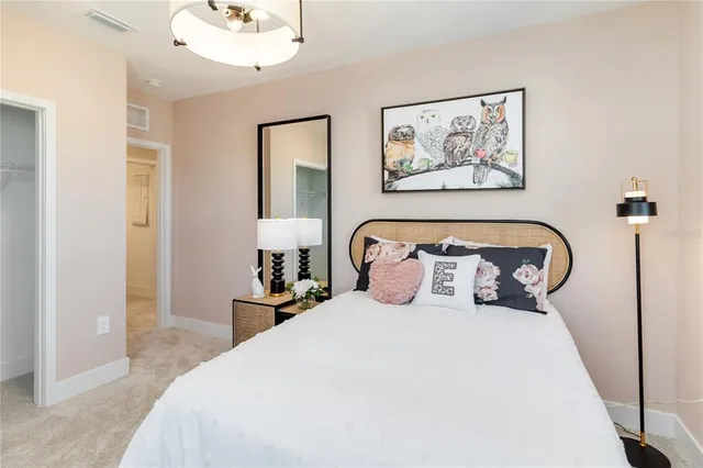 a bedroom with bed and a painting on the wall