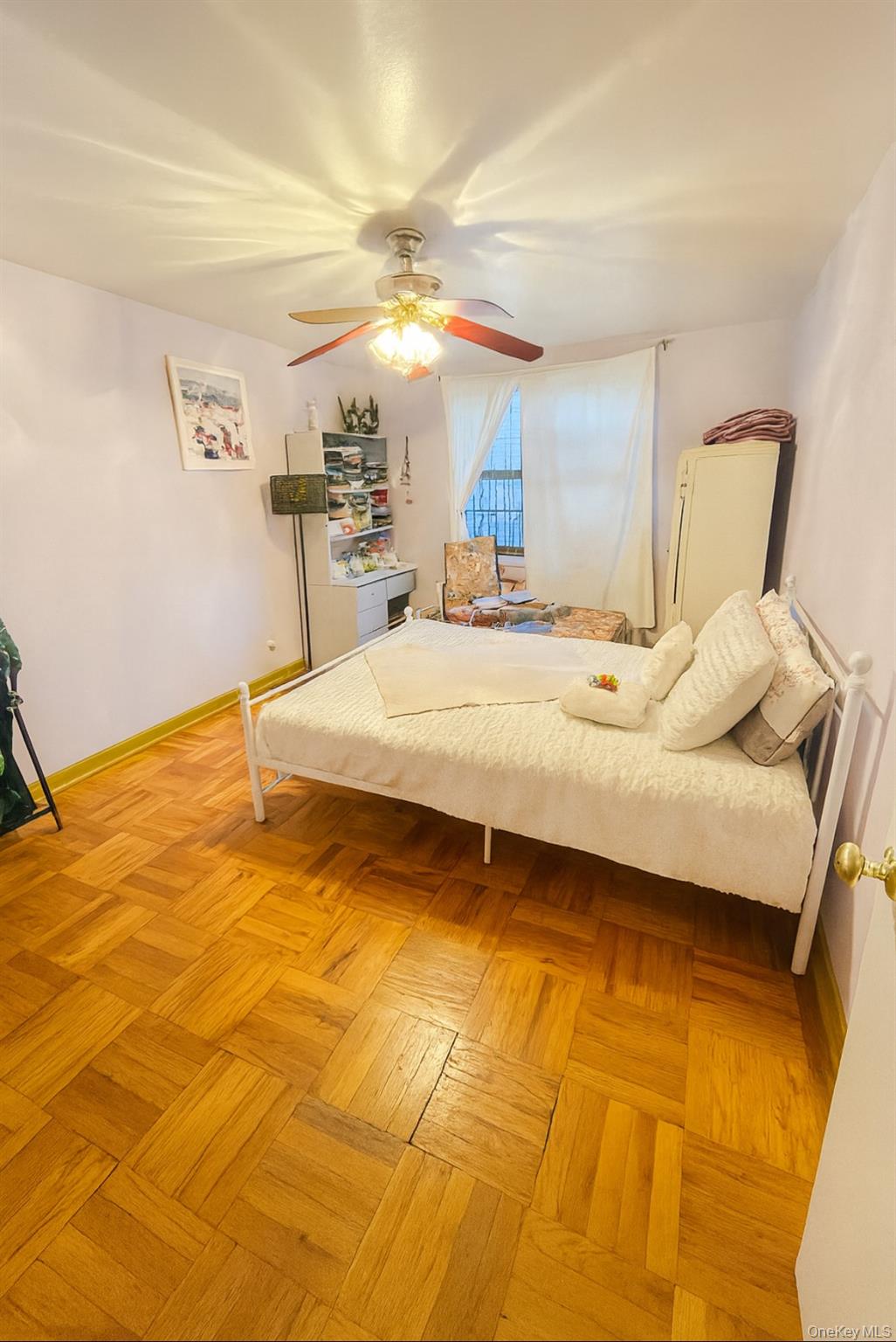 86-04 Grand Avenue, Unit 2D Queens, NY 11373 - Photo 3 of 13 a spacious bedroom with a bed a mirror and lamp