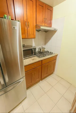 a kitchen with stainless steel appliances a refrigerator a sink and cabinets