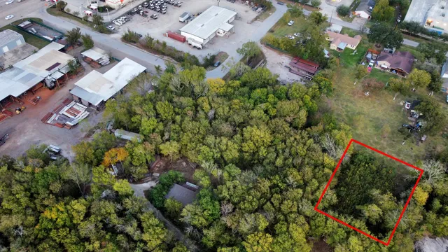 an aerial view of residential house with outdoor space and trees all around