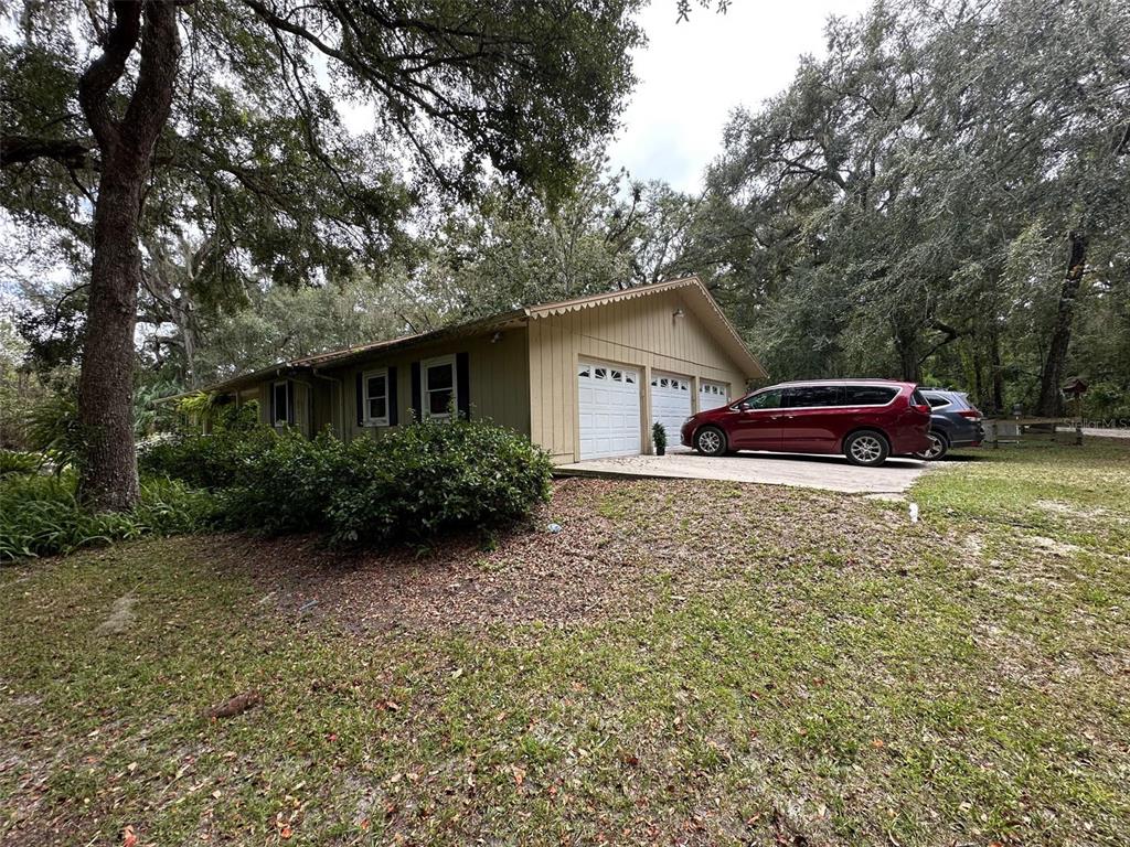 24392 Lanark Road Brooksville, FL 34601 - Photo 2 of 58 a front view of a house with garden