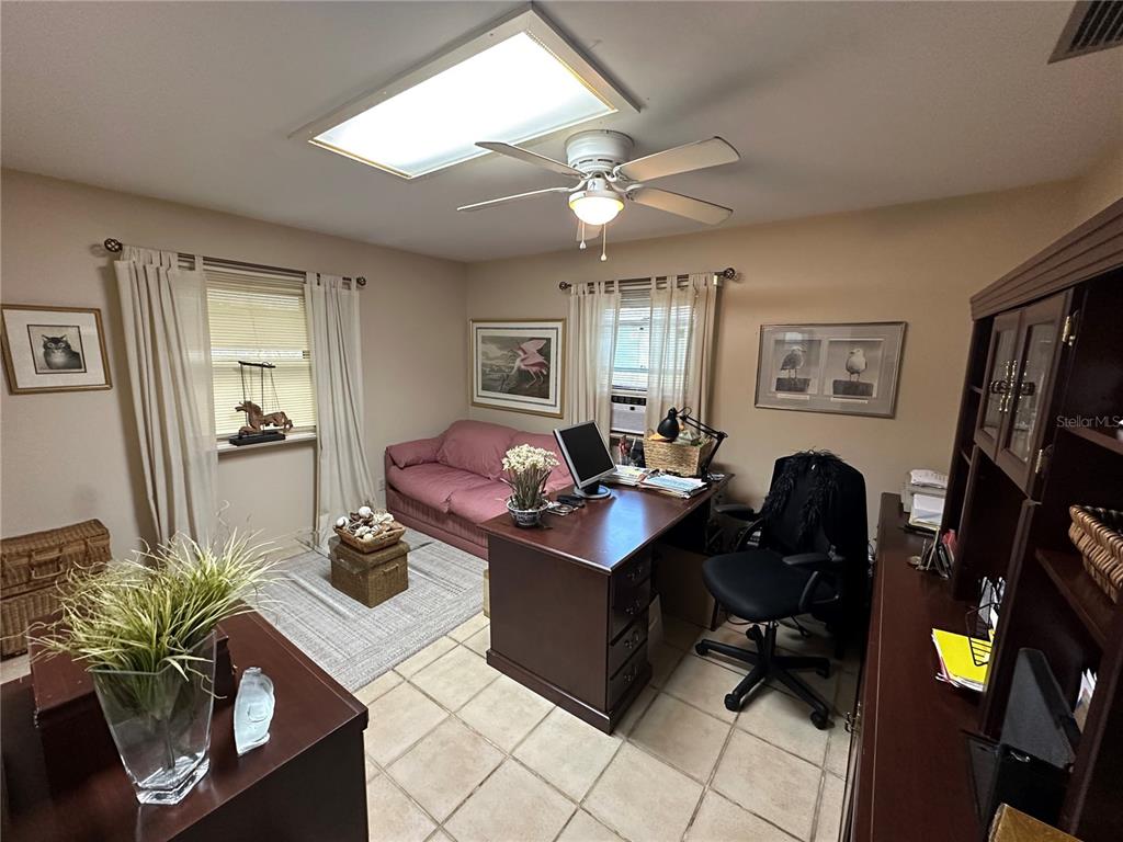 24392 Lanark Road Brooksville, FL 34601 - Photo 38 of 58 a living room with furniture a chandelier and a flat screen tv