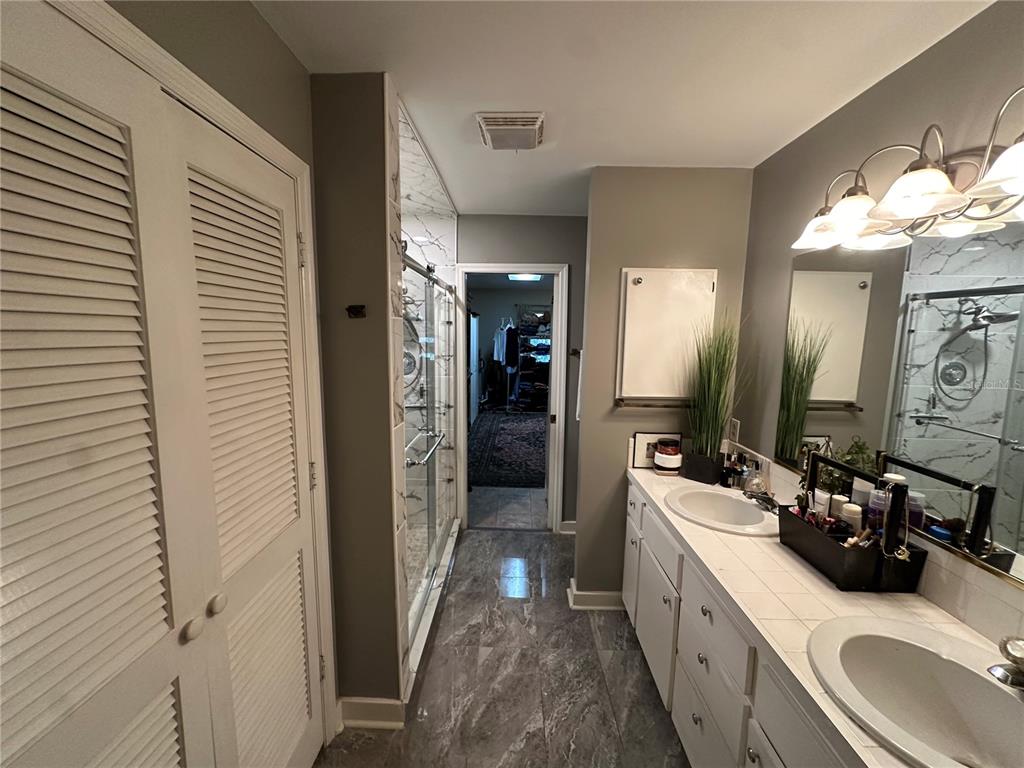24392 Lanark Road Brooksville, FL 34601 - Photo 49 of 58 a bathroom with a double vanity sink and a mirror