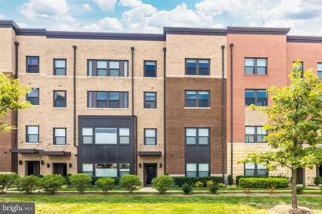 a front view of a residential apartment building with a yard