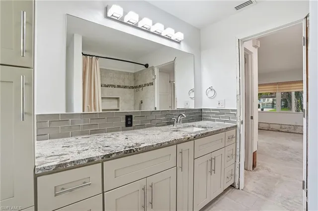 a bathroom with a granite countertop sink and a mirror