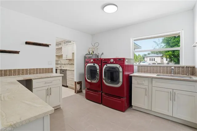 a utility room with cabinets dryer and washer