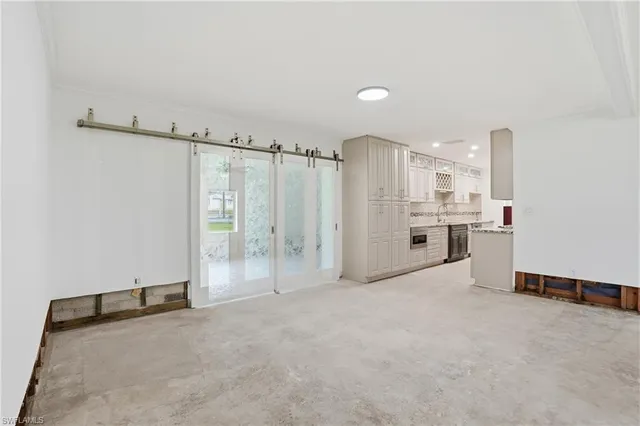 a view of a kitchen with refrigerator and white cabinets
