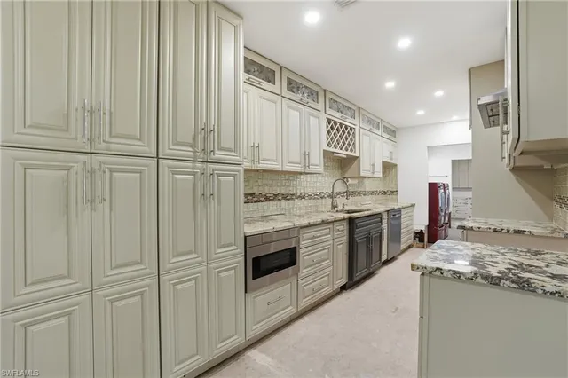 a kitchen with stainless steel appliances granite countertop a stove a sink and a refrigerator