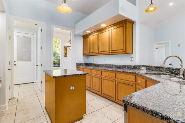 a kitchen with granite countertop a sink and cabinets