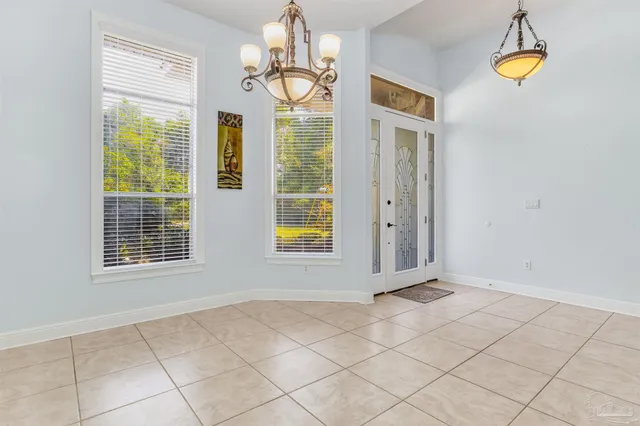 a view of an empty room with a window and chandelier