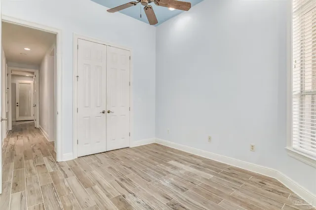 an empty room with a window and a ceiling fan