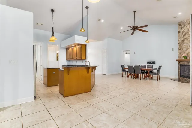 a large kitchen with granite countertop a sink window and cabinets
