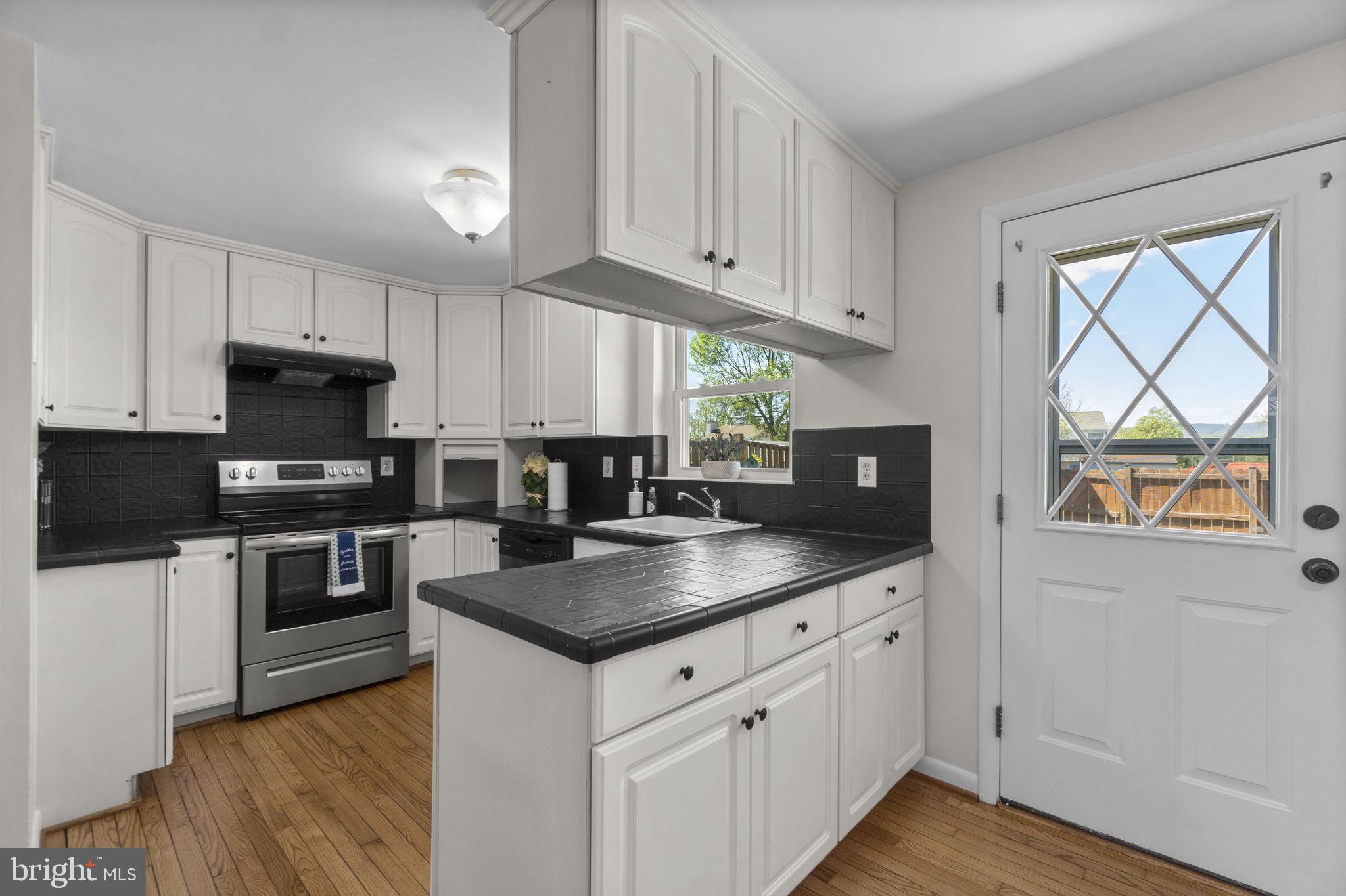 1715 Country Court Frederick, MD 21702 - Photo 8 of 31 a kitchen with granite countertop a stove a sink and a microwave