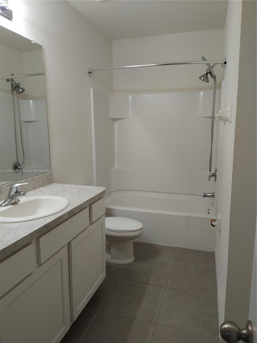 8749 Falling Blue Place Riverview, FL 33578 - Photo 23 of 51 a bathroom with a granite countertop toilet a sink and a bathtub