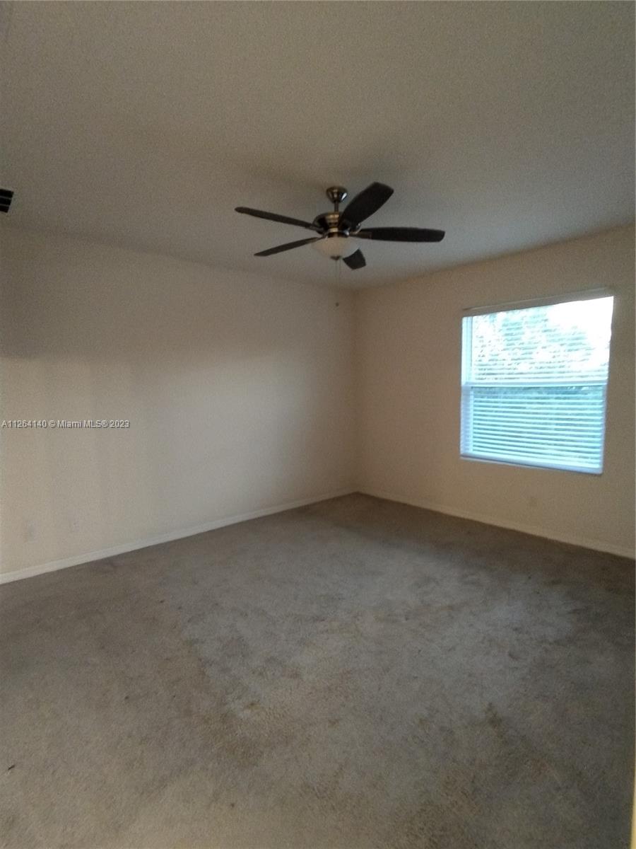 8749 Falling Blue Place Riverview, FL 33578 - Photo 39 of 51 an empty room with windows and fan