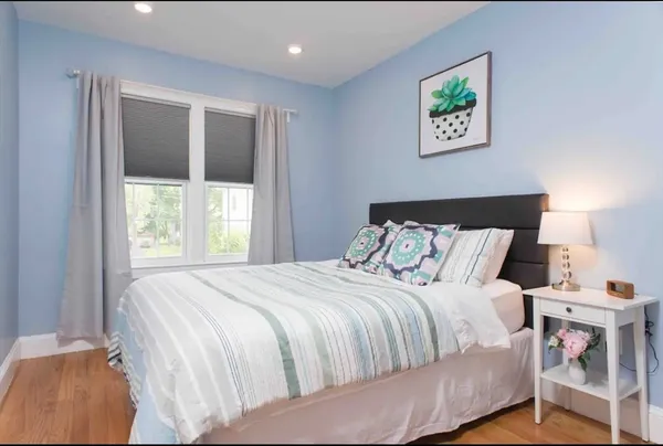 a bedroom with a bed and a painting on the wall