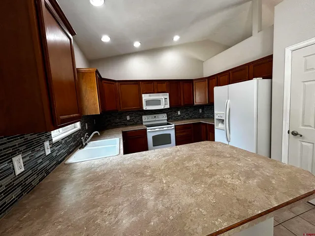 a kitchen with stainless steel appliances a refrigerator and a stove top oven