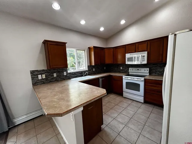 a kitchen with stainless steel appliances granite countertop a stove sink and cabinets