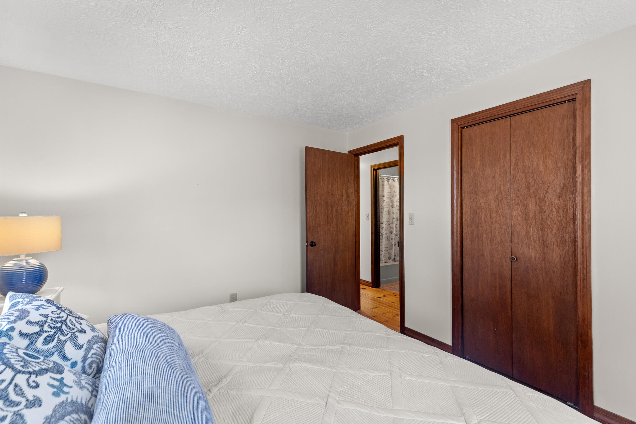 20 Stone Court Eastham, MA 02642 - Photo 15 of 31 a bedroom with a bed and a lamp on dresser