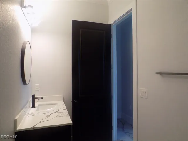 a bathroom with a granite countertop bathtub sink vanity and toilet