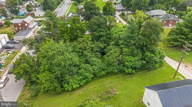 an aerial view of residential houses with outdoor space and trees