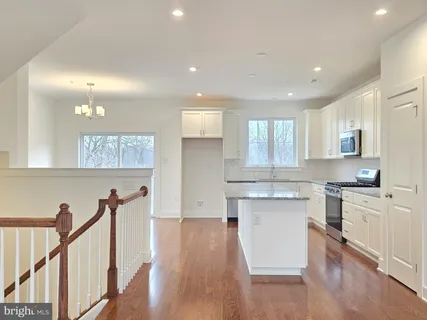 a kitchen with granite countertop white cabinets and appliances