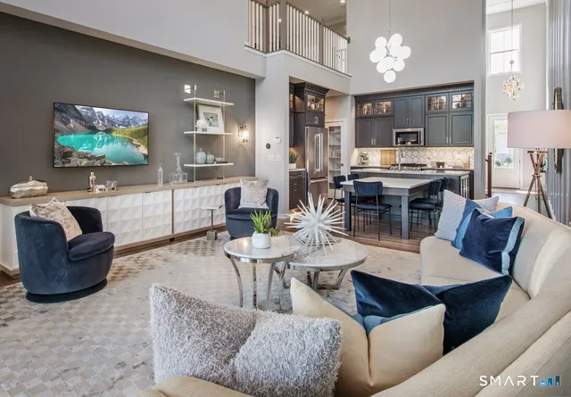 a living room with furniture kitchen view and a flat screen tv
