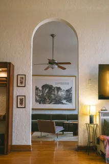 a living room with furniture and painting on the wall