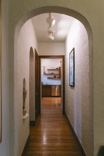 a view of a hallway with wooden floor and a chandelier
