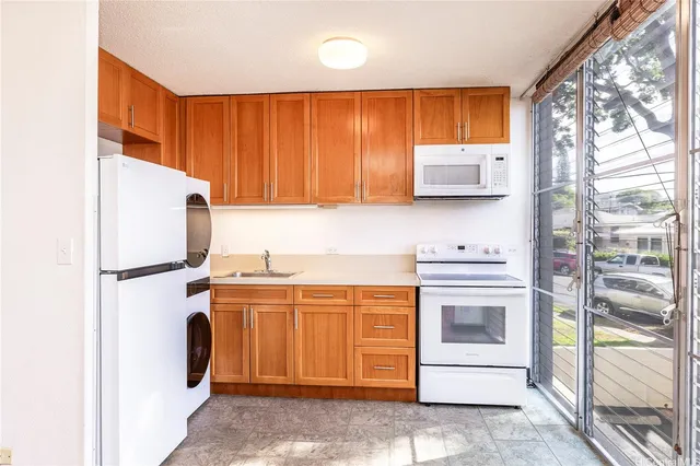a kitchen with stainless steel appliances granite countertop a refrigerator and a stove