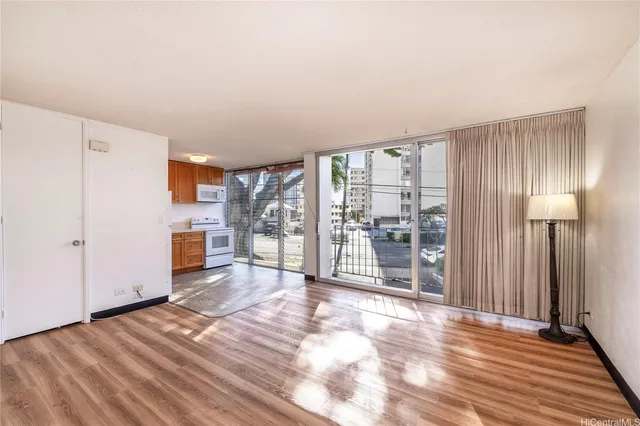 a view of a big room with wooden floor and windows