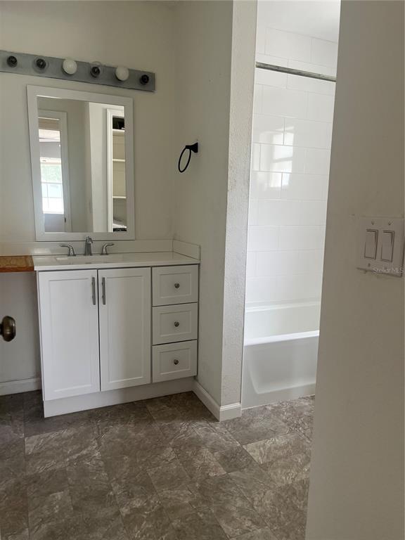 1585 Triangle Drive Mount Dora, FL 32757 - Photo 14 of 19 a bathroom with a granite countertop sink a mirror and a bathtub