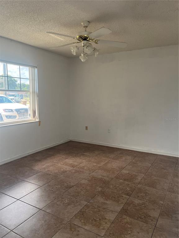1585 Triangle Drive Mount Dora, FL 32757 - Photo 9 of 19 an empty room with a ceiling fan and window