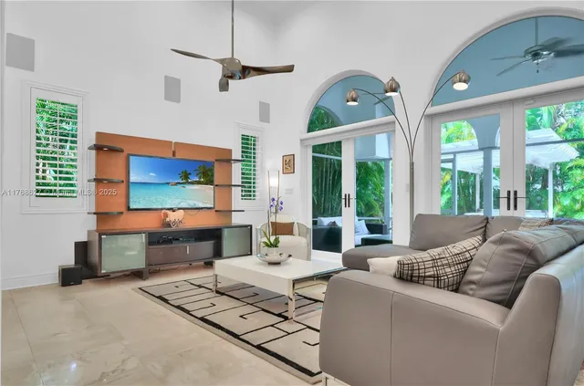 a living room with furniture a flat screen tv and a large window