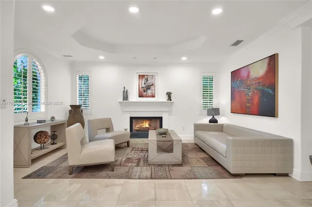 a living room with furniture a fireplace and a large window
