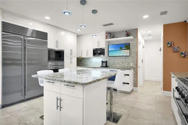 a kitchen with stainless steel appliances granite countertop a sink and a refrigerator