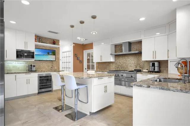 a large kitchen with stainless steel appliances granite countertop a stove and a sink