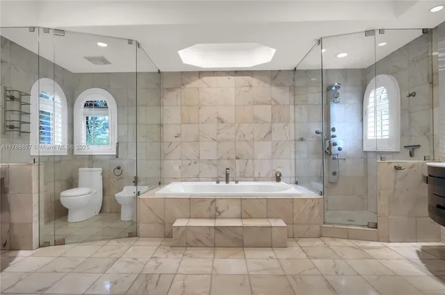 a bathroom with a double vanity sink mirror and bathtub