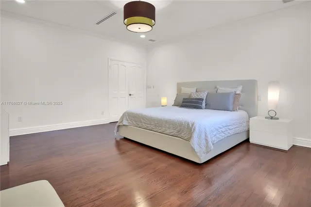 a bedroom with a bed flowerpot and wooden floor