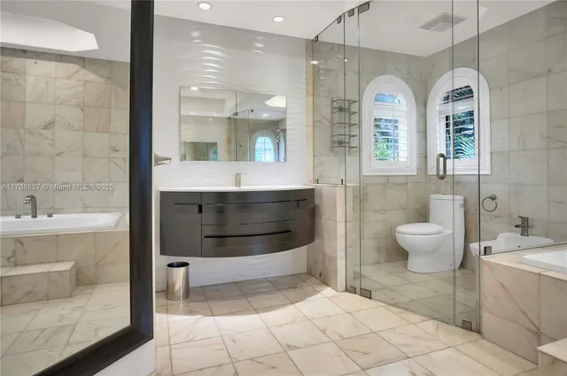 a bathroom with a double vanity sink toilet and shower