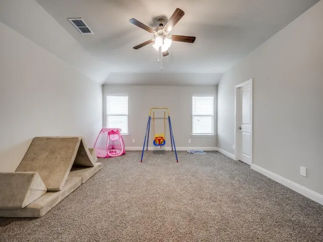 a view of an empty room with cabinet and a chandelier fan