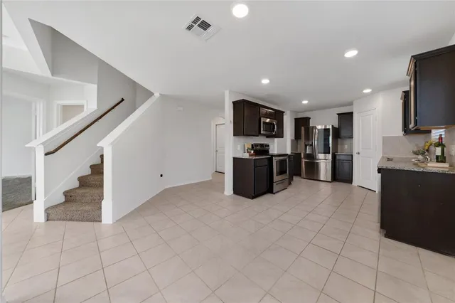 a view of a kitchen with white cabinets and entryway