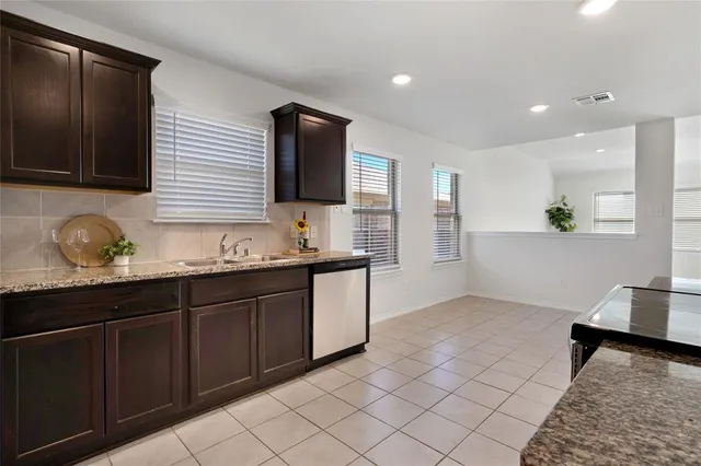 a kitchen with stainless steel appliances granite countertop a sink and a stove