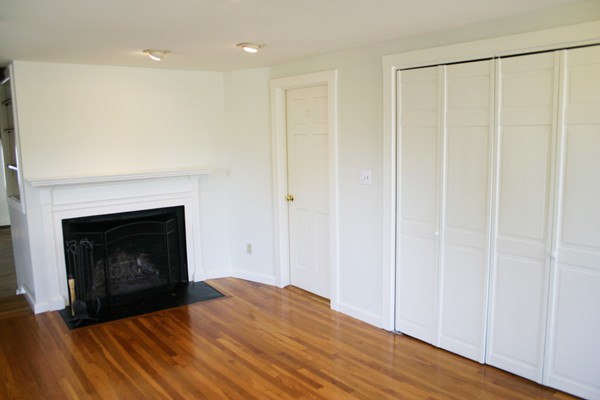 526 Centre Street, Unit 3 Boston, MA 02130 - Photo 11 of 15 a view of an empty room with wooden floor and a fireplace