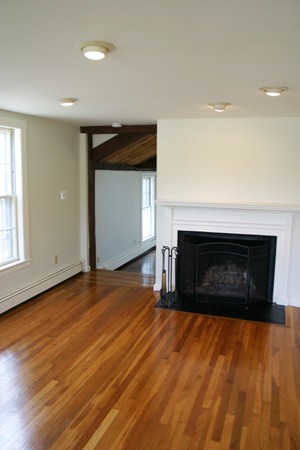 526 Centre Street, Unit 3 Boston, MA 02130 - Photo 12 of 15 a view of empty room with wooden floor and fireplace