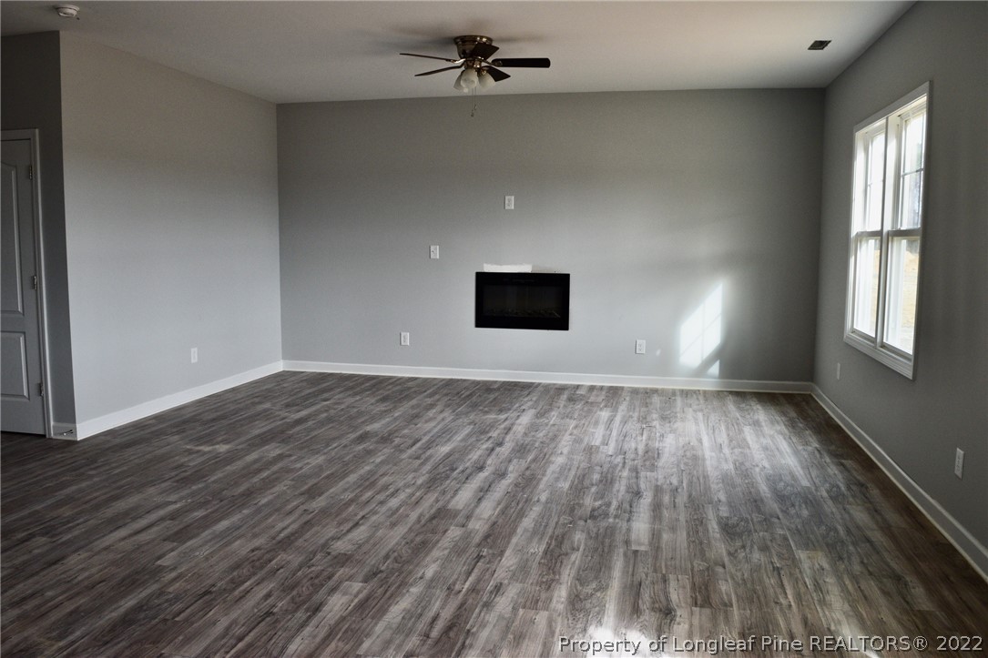 263 McMillan Siding Road Parkton, NC 28371 - Photo 3 of 15 an empty room with wooden floor and windows