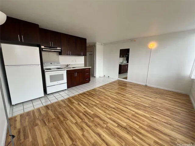 a kitchen with a refrigerator and a stove top oven